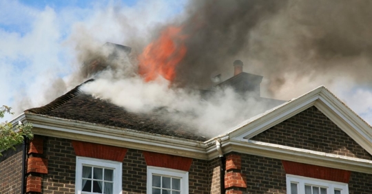 fire and smoke engulfing the roof of a home