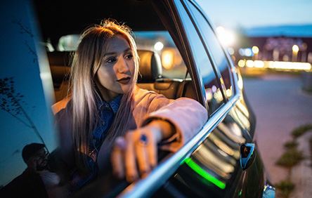 lady in a mid-sized as a passenger vehicle looking out of the window