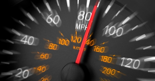 close-up of a speedometer in a car that reads 85 mph