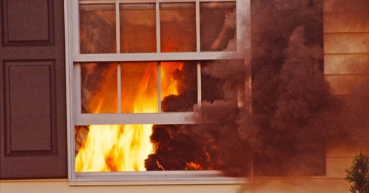 smoke and fire coming out of a window