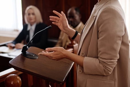 Cropped shot of young female expert witness in beige blazer.