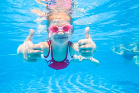 little girl swimming thumbs up