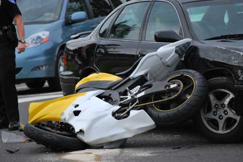 damaged motorcycle laying in road after crash